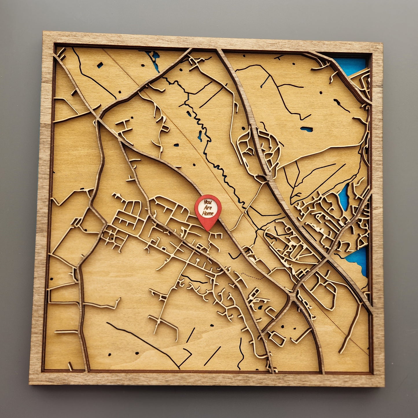 Layered wooden map in frame showcasing detailed geographic design of a custom location.