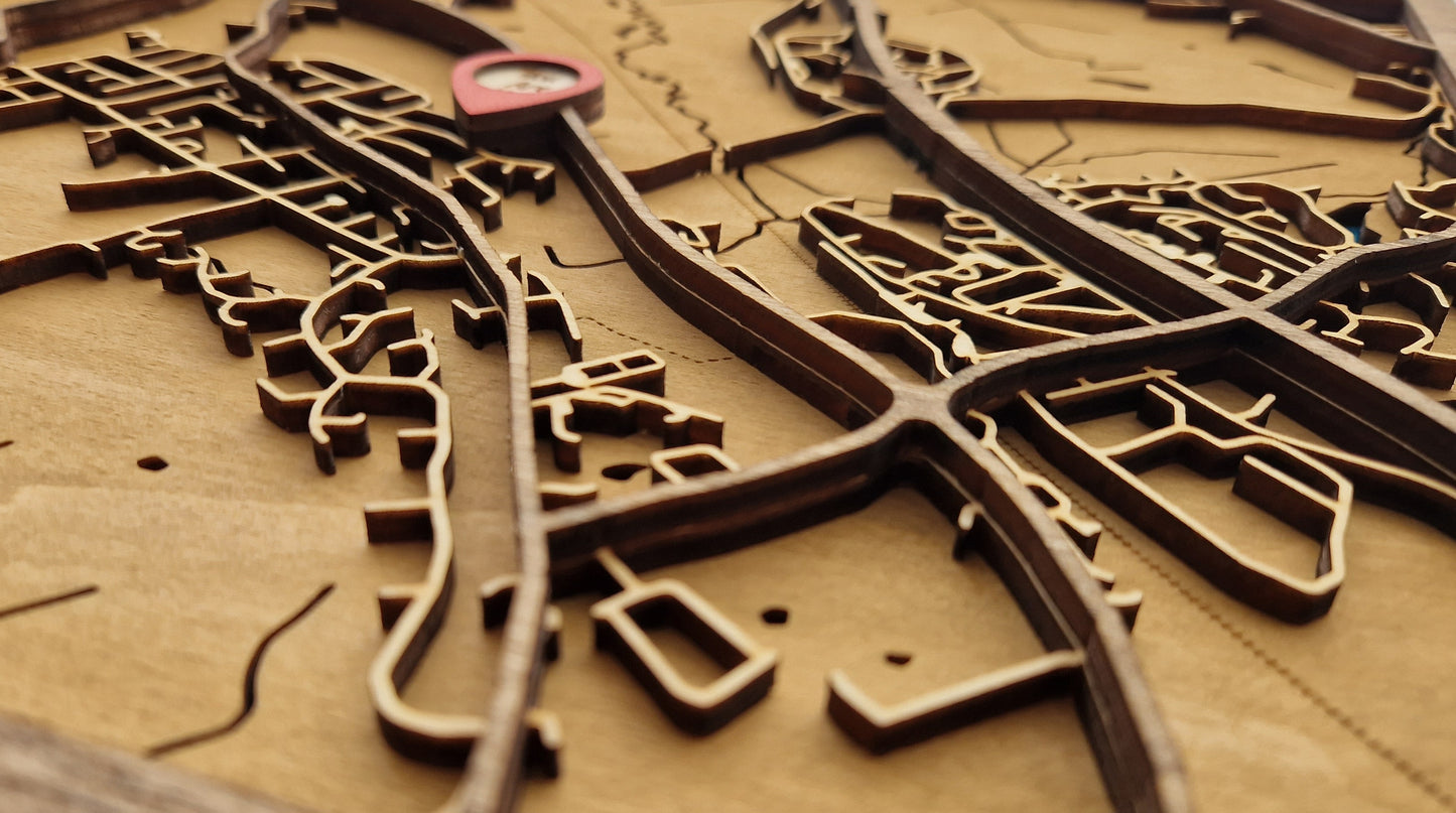 Close-up of a layered wooden map in frame, showcasing intricate, laser-cut details of a chosen location and natural wood grain.