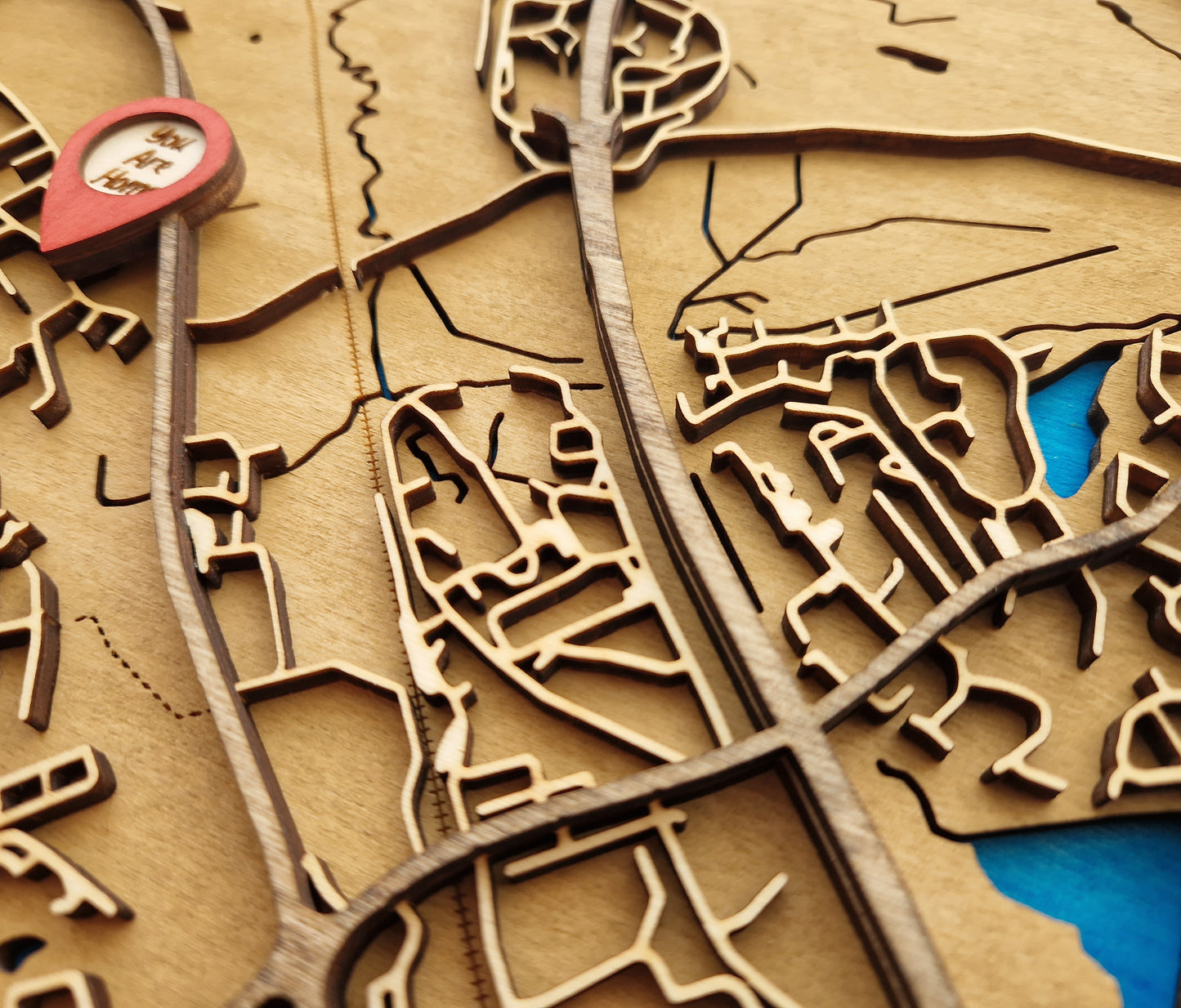 Detailed layered wooden map in frame showcasing custom location with intricate laser-cut design and hand-stained wood grain.