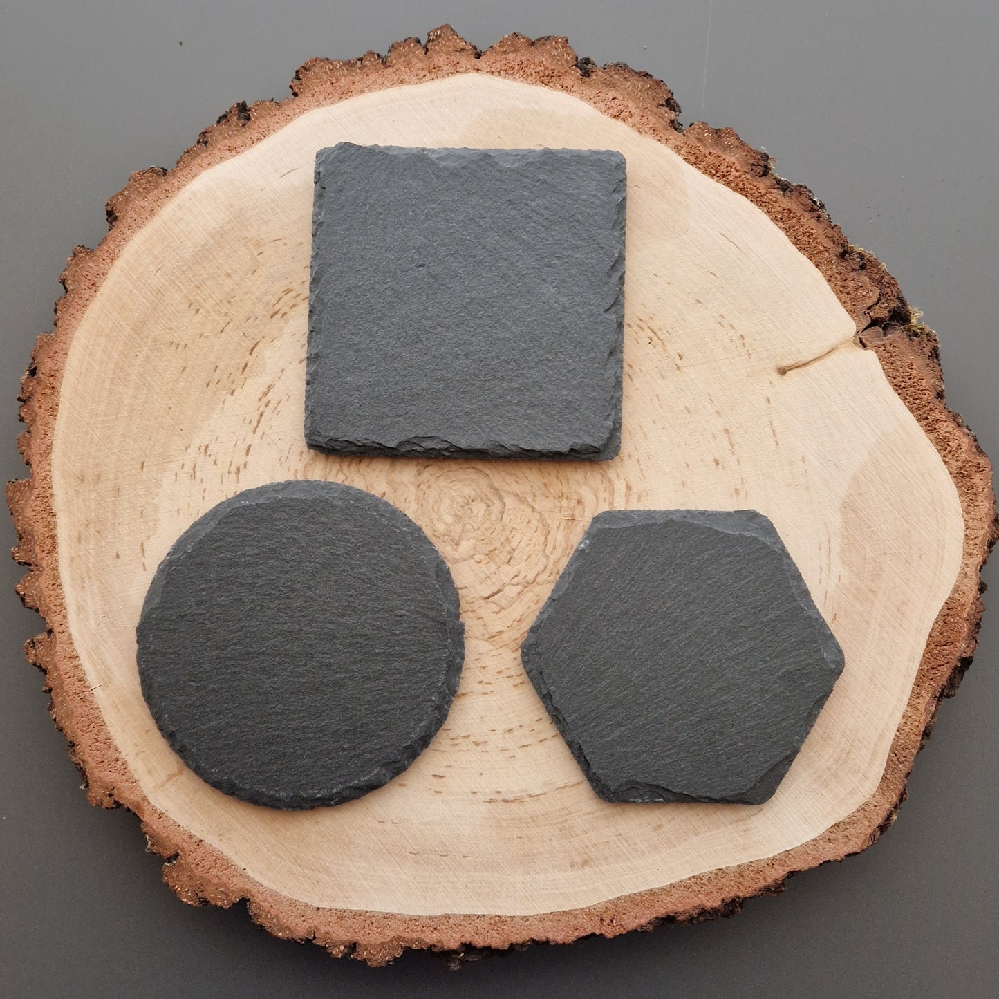 Slate coasters on log slice