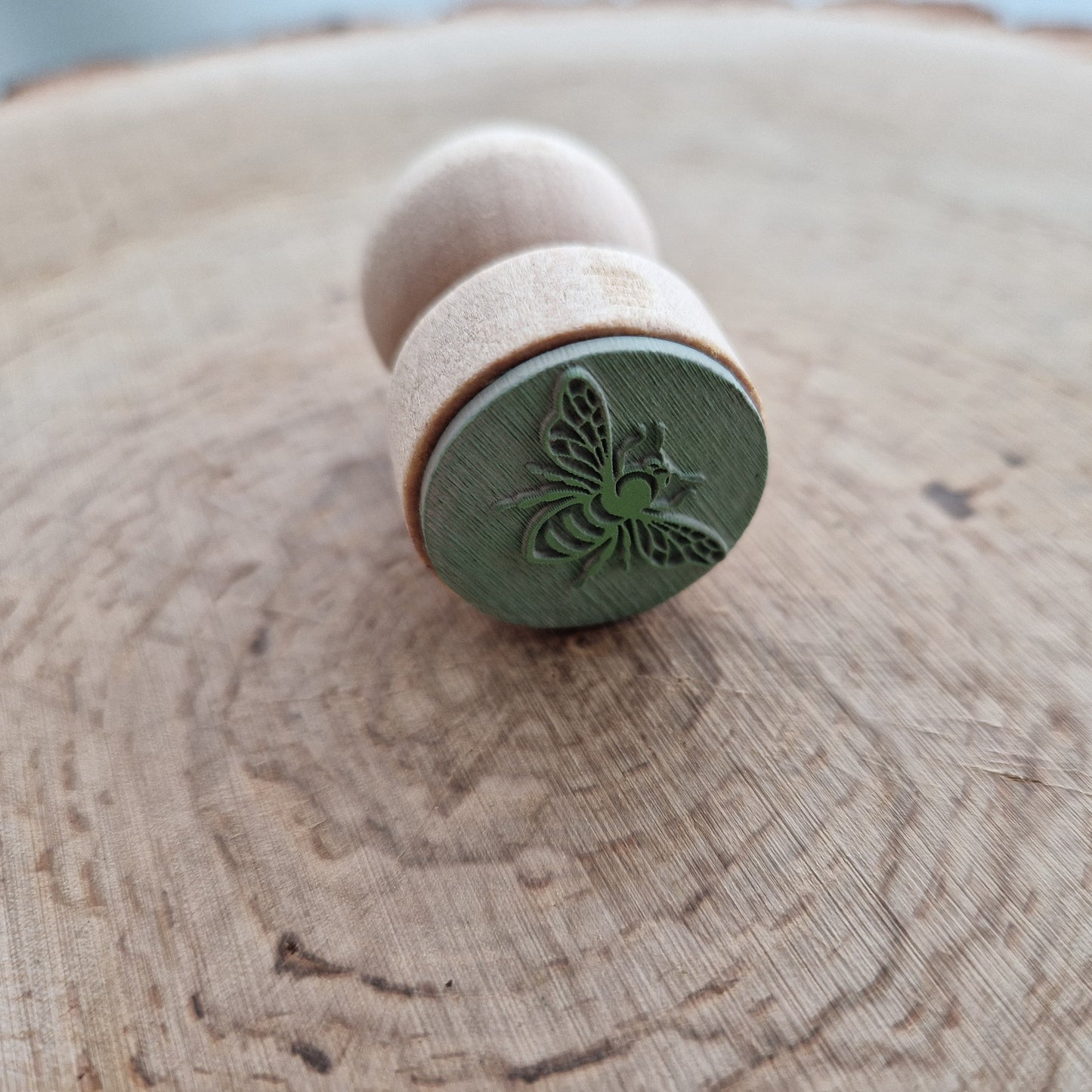 Eco Rubber bee stamp displayed on wooden background