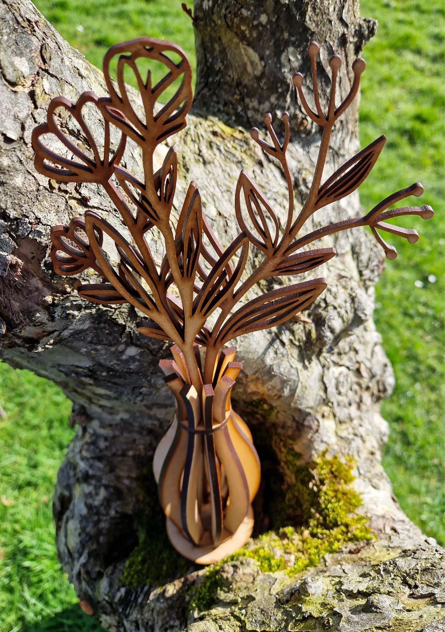 wooden vase and flowers displayed on grass