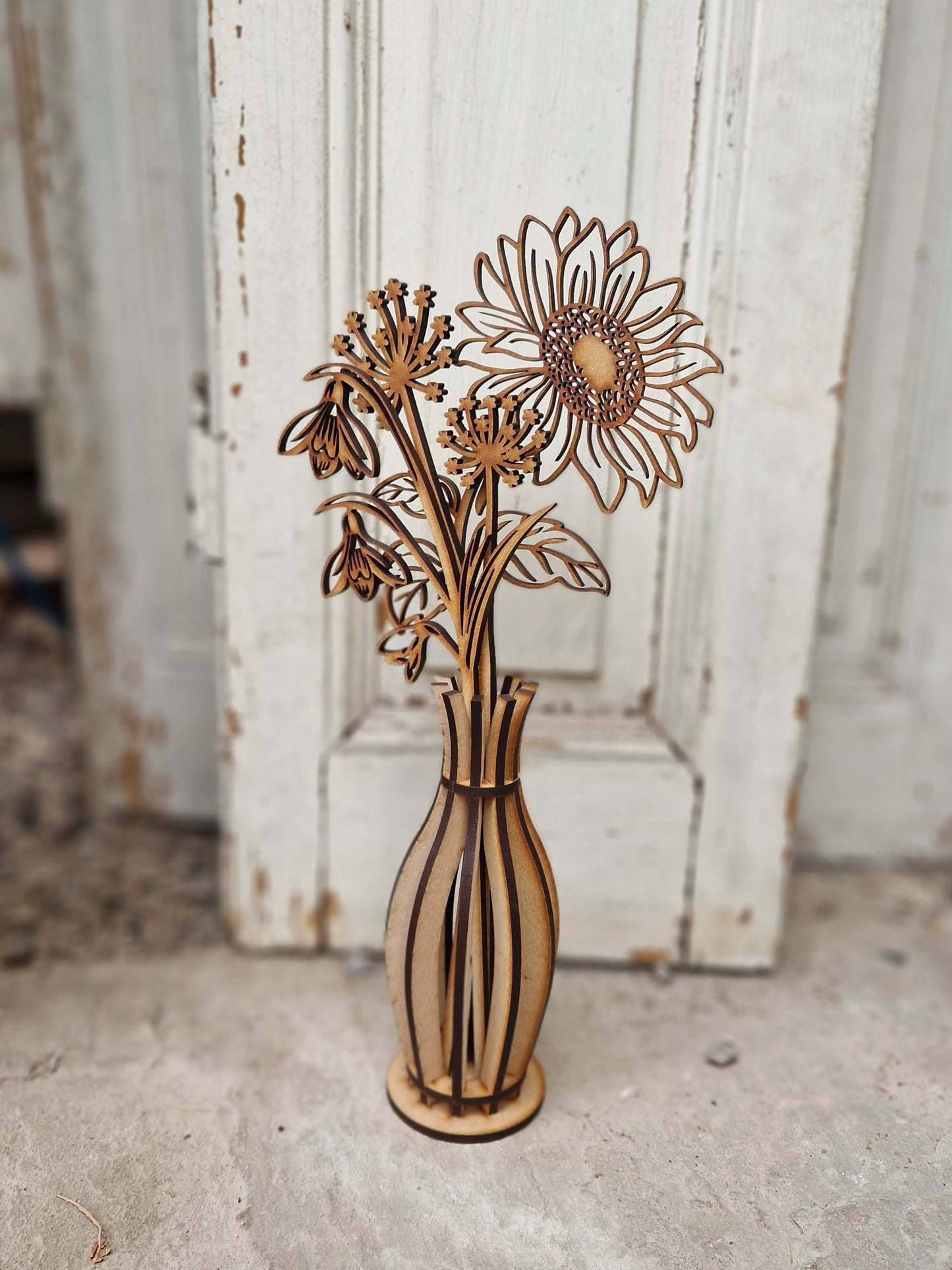 Wooden vase with floral design against a rustic wooden background