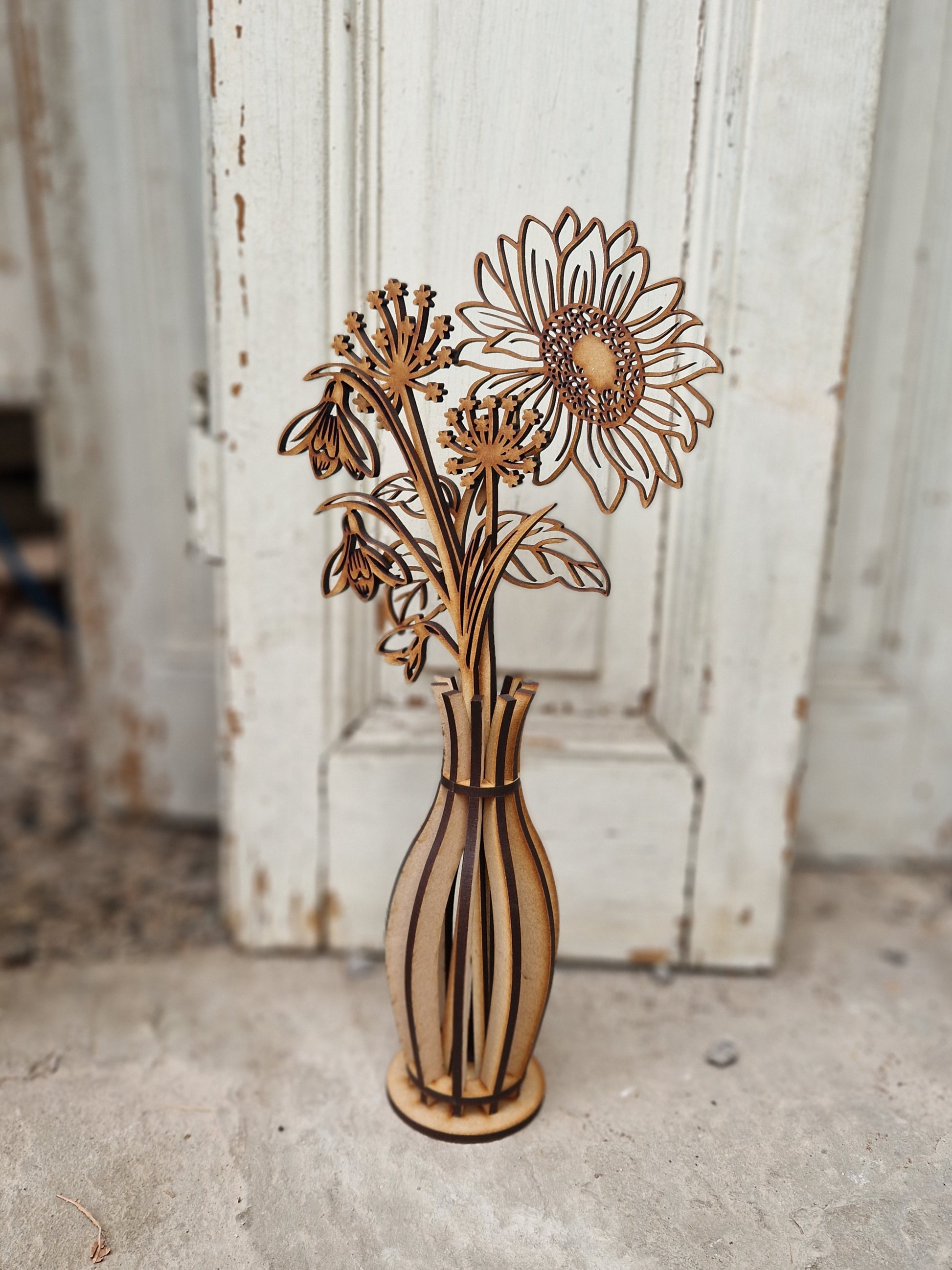 Wooden vase with floral design against a rustic wooden background