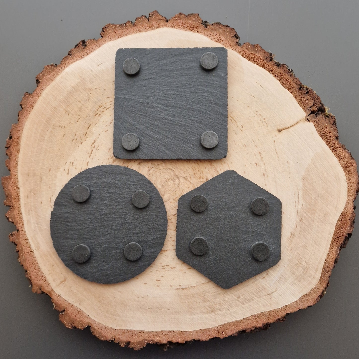 Back of slate coasters displayed on wooden background