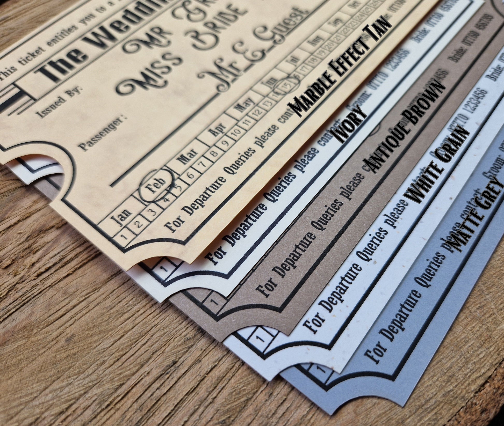Vintage train ticket wedding invites displayed on a wooden background