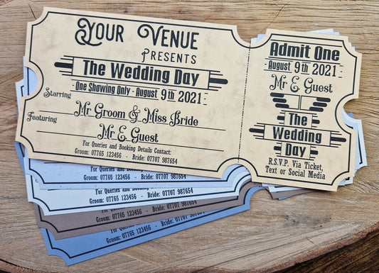 Vintage film ticket wedding invites displayed on a wooden background