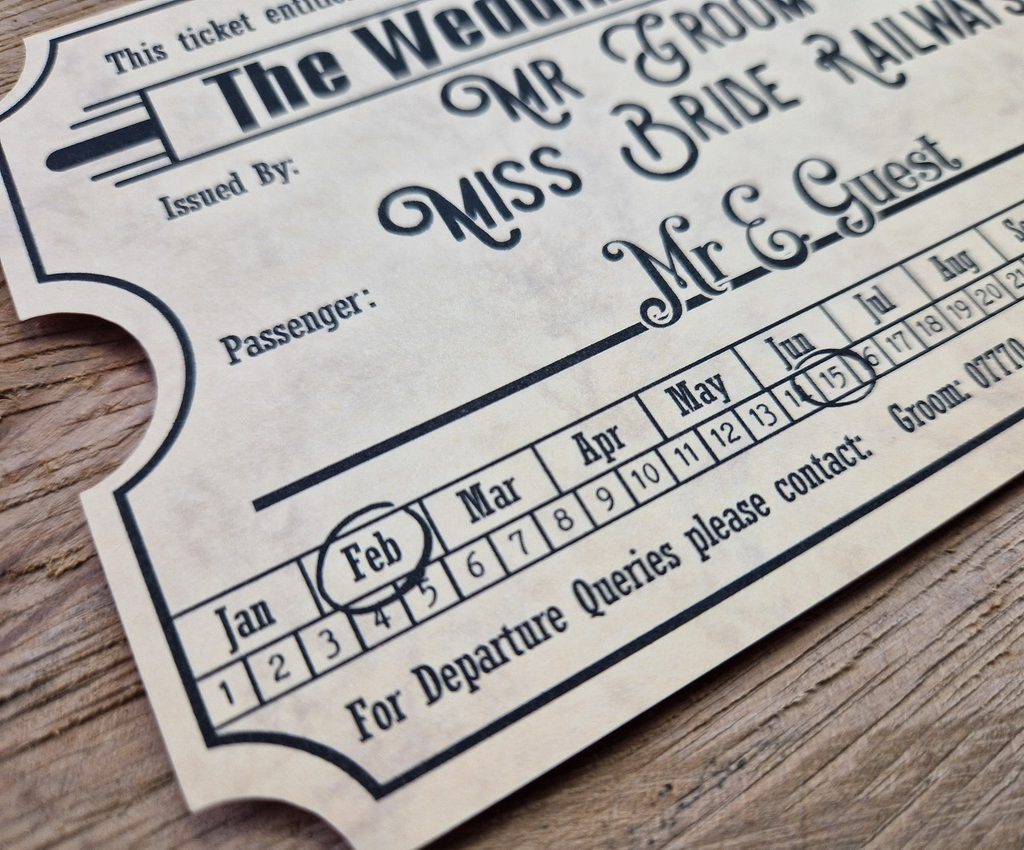 Vintage train ticket wedding invites displayed on a wooden background