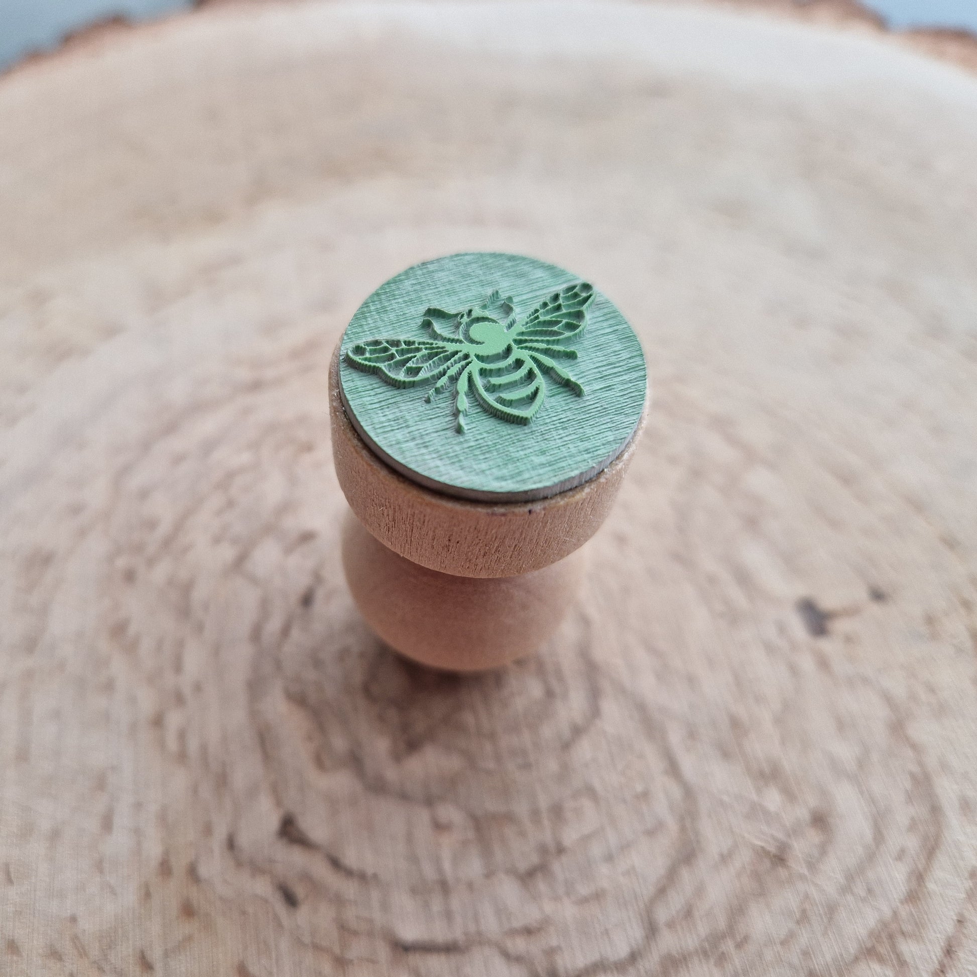 Eco Rubber bee stamp displayed on wooden background