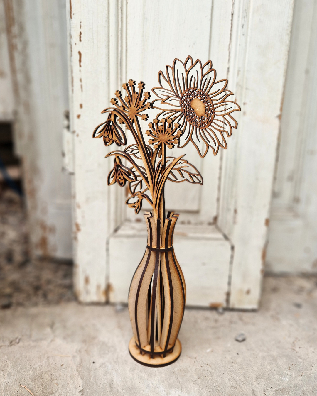 Wooden vase with floral design against a rustic wooden background